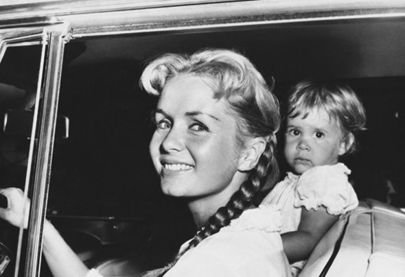 Actress Debbie Reynolds, accompanied by her daughter, Carrie, 2, leaves her home to spend the rest of the day with a girlfriend whom she did not identify, Sept. 10, 1958 in Los Angeles. She said she was leaving "to get away from it all," a reference to the hullabaloo raised over the dating by her husband, Eddie Fisher, of actress Elizabeth Taylor in New York. (AP Photo)